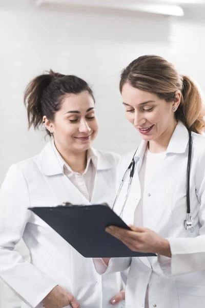 Deux assistantes vêtues de manteaux blancs se parlent au centre de dentisterie — Photo