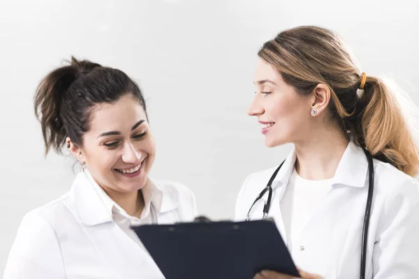 Deux assistantes vêtues de manteaux blancs se parlent au centre de dentisterie — Photo