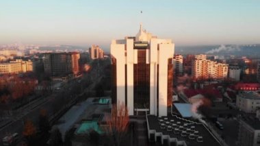 Güneşin doğuşunda Cumhurbaşkanlığı binasının havadan drone görünümü. Sıcak güneş, şehir ve araba arka planda sürme. Chisinau, Moldova