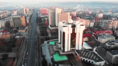 Güneşin doğuşunda Cumhurbaşkanlığı binasının havadan drone görünümü. Sıcak güneş, şehir ve araba arka planda sürme. Chisinau, Moldova