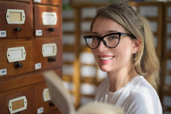 Blonde woman reading a book in public library