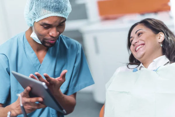 Dentiste montrant à son patient une image sur un appareil électronique — Photo