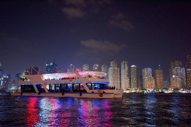 Renkli turistik tekneler ile gece Dubai Marina
