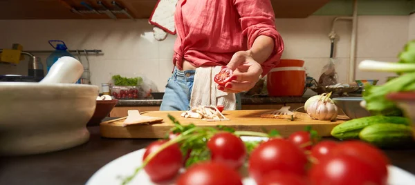 Foto seorang wanita memegang tomat ceri potong di tangan — Stok Foto