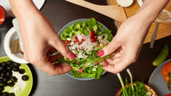Kvinna händer lägga Microgreens till hälsosam sallad — Stockfoto