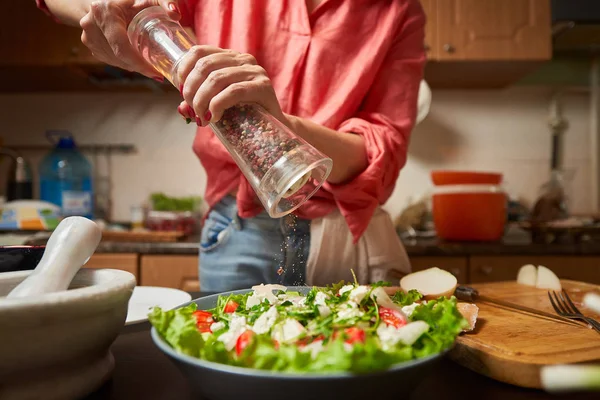 Wanita menggiling campuran lada menjadi salad Yunani sehat — Stok Foto