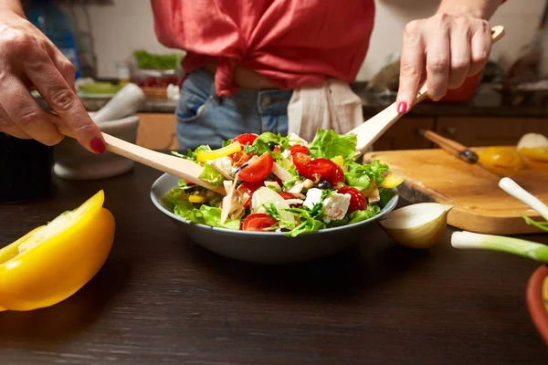 Mãos de mulher misturando salada grega saudável — Fotografia de Stock