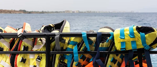 Chalecos de seguridad colgados en las barras de un barco —  Fotos de Stock