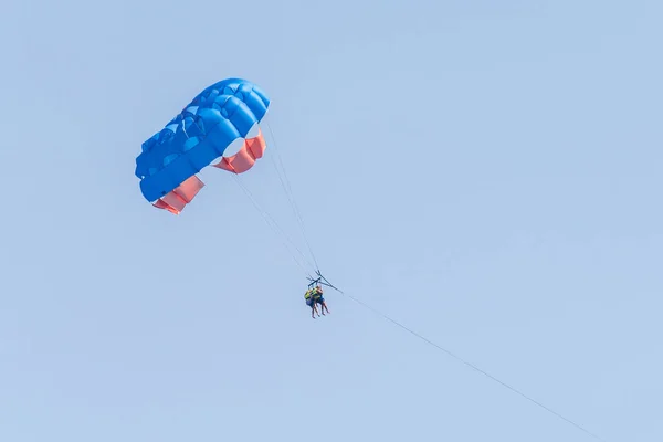 Two persons on a parasailing in the sky