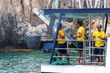 İnsanlar Meditereanean denizde bir feribot teknede barbekü yapma