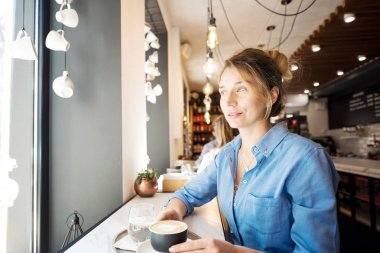 Mavi gömlekli mutlu genç sevimli kadın