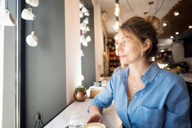 Mavi gömlekli mutlu genç sevimli kadın