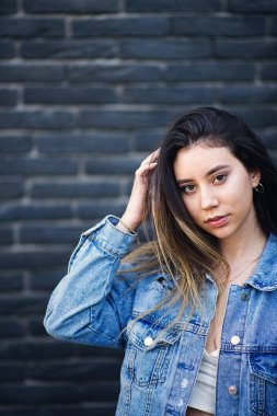 Siyah tuğla duvara poz veren vurucu saçlı genç beyaz kız