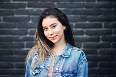 Siyah tuğla duvara poz veren vurucu saçlı genç beyaz kız