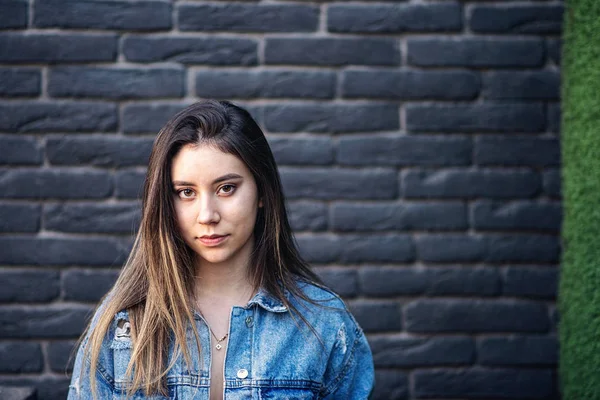 Jovem caucasiana com cabelo greve posando na parede de tijolo preto — Fotografia de Stock