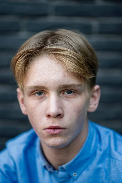 Young caucasian adult with blue eyes and blonde hair posing on b