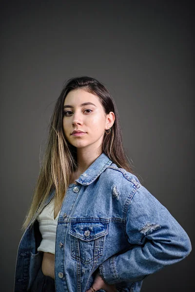 Young caucasian girl with brown hair posing on grey background — Stock Photo, Image