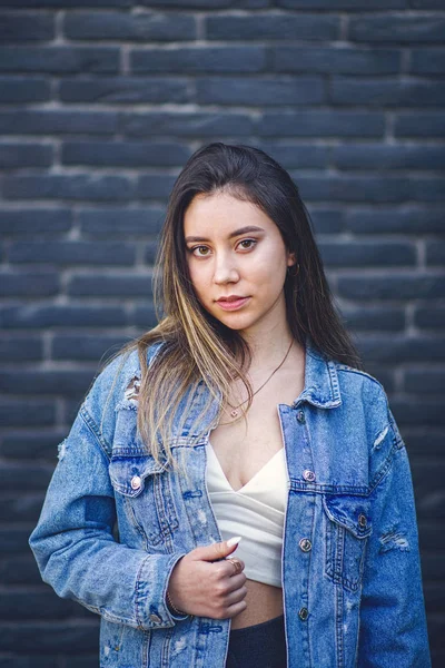 Jovem caucasiana com cabelo greve posando na parede de tijolo preto — Fotografia de Stock