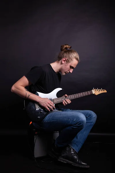 Jovem caucasiano adulto tocando guitarra no estúdio — Fotografia de Stock