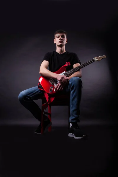 Joven caucásico adulto posando en el estudio con guitarra rock —  Fotos de Stock