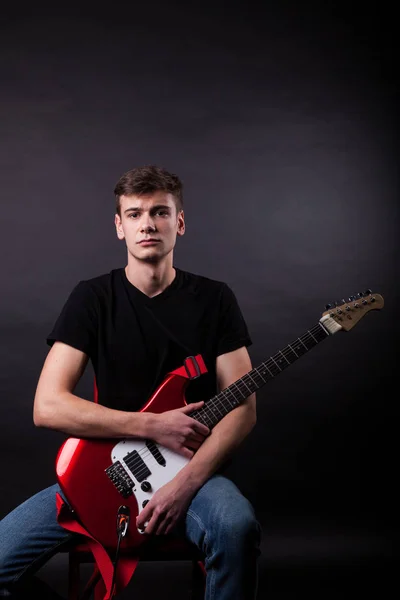 Jovem caucasiano adulto posando no estúdio com guitarra rock — Fotografia de Stock