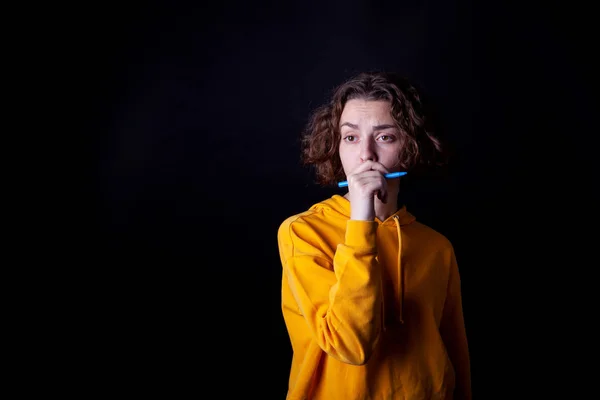 Молода біла дівчина в жовтому светрі позує в студії — стокове фото