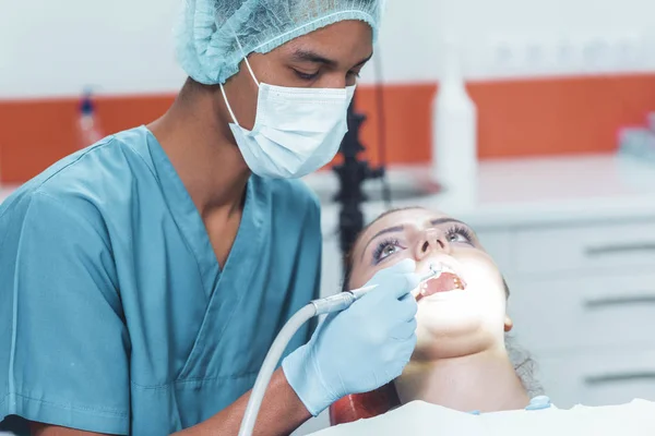 Odontólogo rechinar los dientes de un paciente en la odontología — Foto de Stock