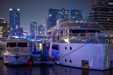 Dubai Marina limanında gece park edilmiş yatlar