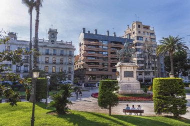 Banktaki insanlar parktaki imparator heykeline hayran.