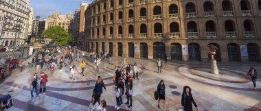 Valencia'da ünlü bir boğa güreşi olan Plaza de Toros yakınlarında yürüyen insanlar