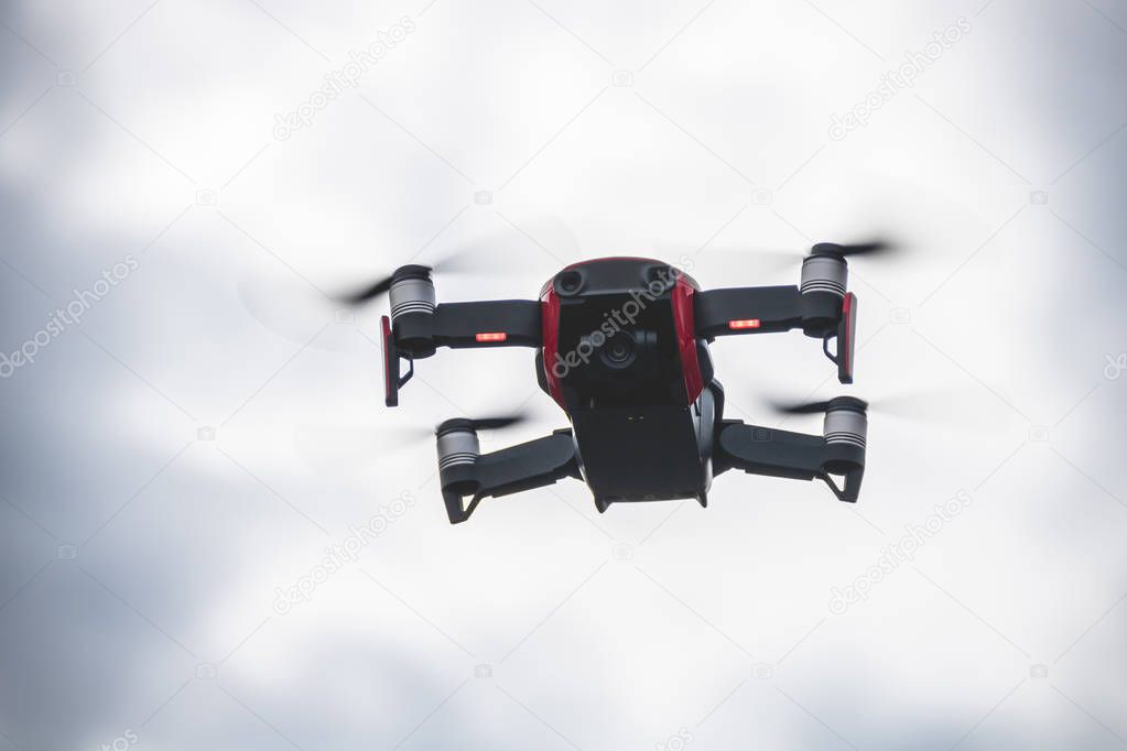 Small red drone in the air with the camera looking downwards