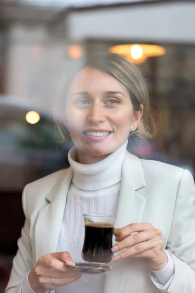 Happy young blonde woman in white suite