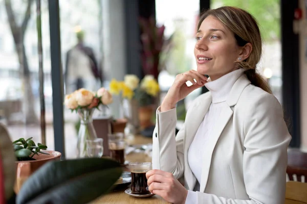 Happy young blonde woman in white suite