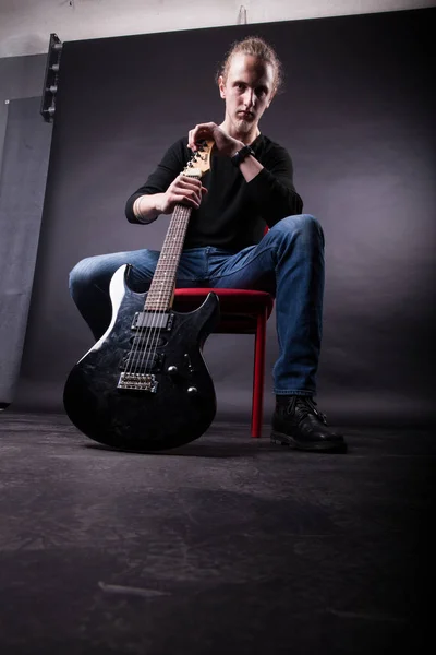 Jovem caucasiano adulto posando no estúdio com guitarra rock — Fotografia de Stock