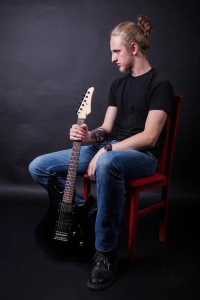ロックギターでスタジオでポーズをとる若い白人の大人 — ストック写真