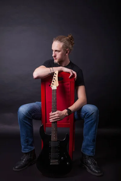 Jovem caucasiano adulto posando no estúdio com guitarra rock — Fotografia de Stock