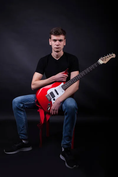 Jovem caucasiano adulto posando no estúdio com guitarra rock — Fotografia de Stock