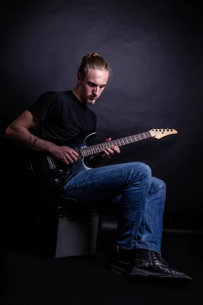 Jovem caucasiano adulto tocando guitarra no estúdio — Fotografia de Stock