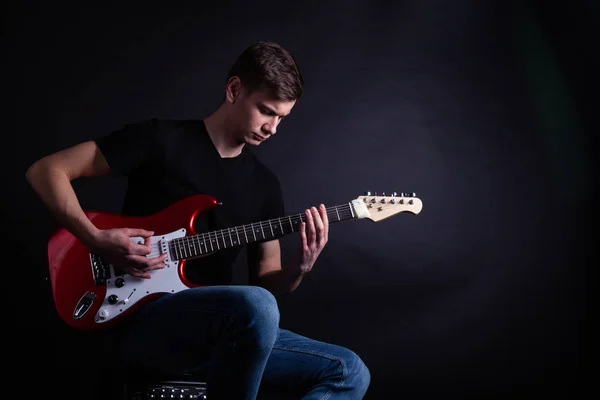 Joven caucásico adulto tocando la guitarra en el estudio —  Fotos de Stock