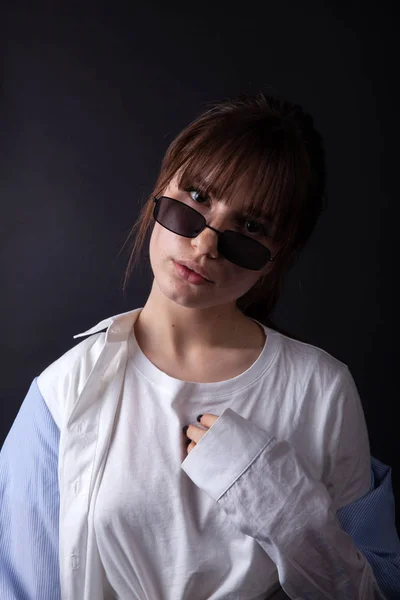 Caucasian Girl in white shirt with black sunglasses posing in the studio — Stock Photo, Image