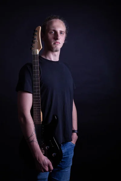 Joven caucásico adulto posando con guitarra eléctrica en el estudio —  Fotos de Stock