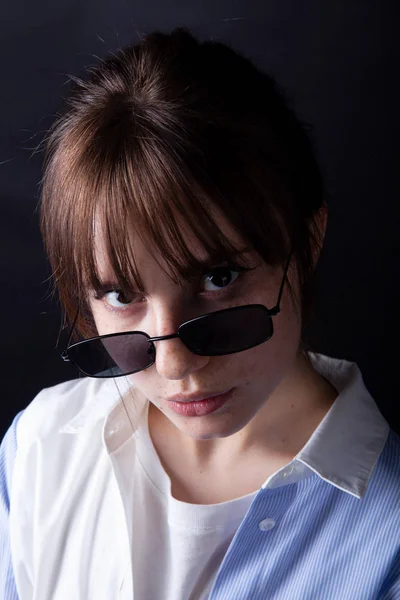 Caucásico Chica en camisa blanca con gafas de sol negras posando en el estudio — Foto de Stock