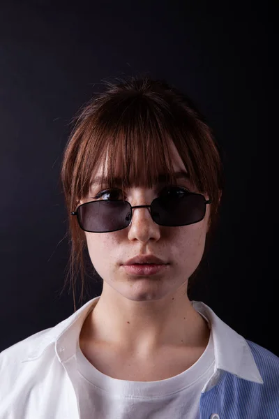 Caucásico Chica en camisa blanca con gafas de sol negras posando en el estudio — Foto de Stock