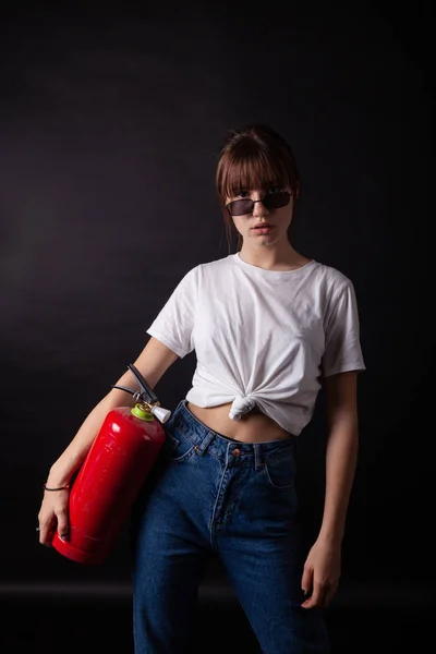 Young caucasian lady posing with fire extinguisher in hand — Stock Photo, Image