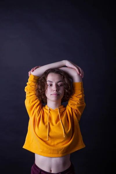 Young caucasian highschool girl in yellow hoodie posing in the studio — Stock Photo, Image