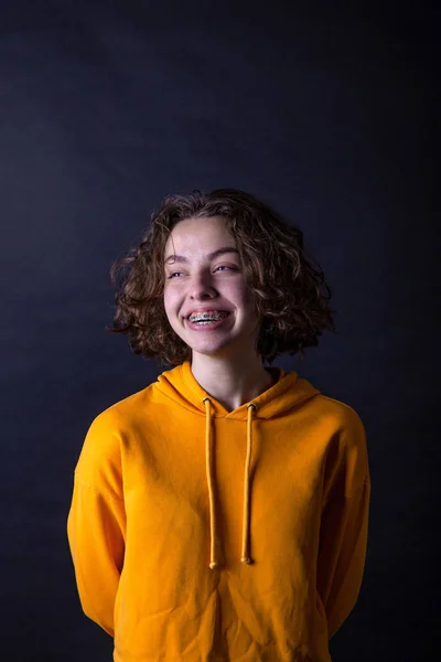Joven chica de secundaria caucásica con capucha amarilla posando en el estudio — Foto de Stock