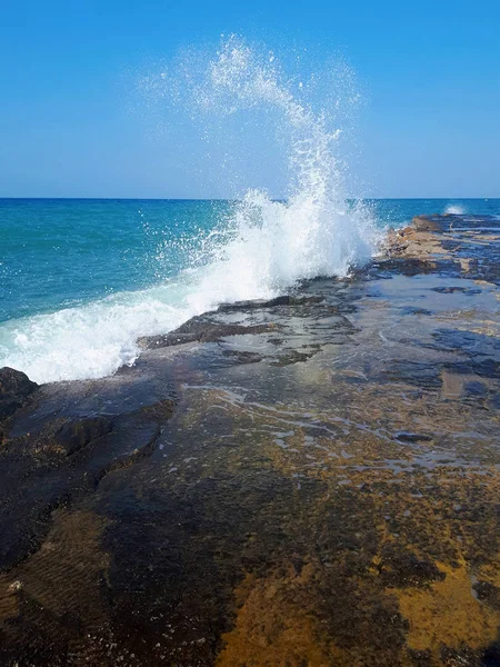 Вода брызгает на море и пляж с голубым небом — стоковое фото