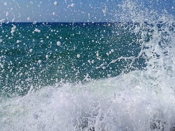 Vattenstänk vid havet och stranden med blå himmel — Stockfoto