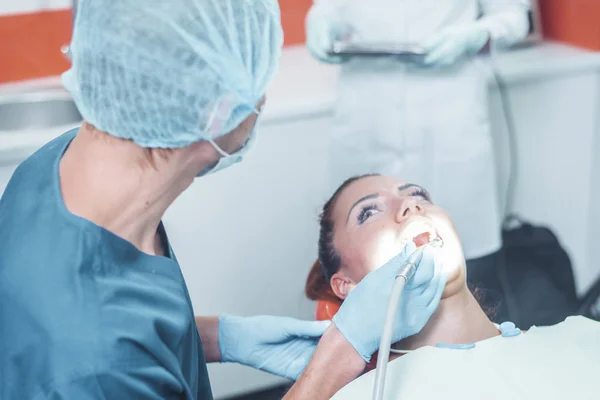 Odontólogo rechinar los dientes de un paciente en la odontología — Foto de Stock