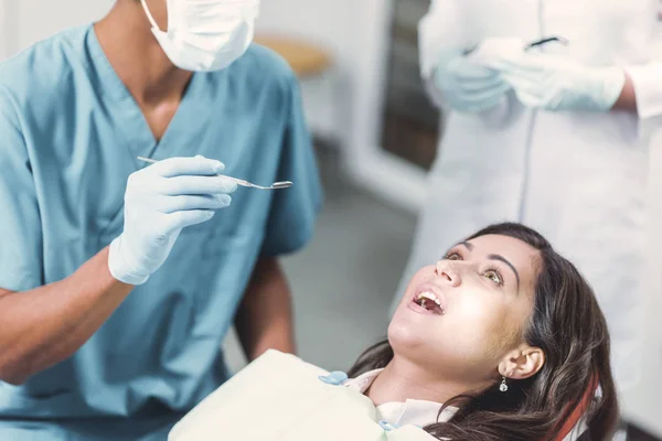 Odontólogo rechinar los dientes de un paciente en la odontología — Foto de Stock